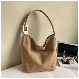 Detail of a large khaki matte tote bag in a minimalist hobo silhouette for daily use