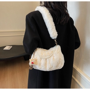 Détail du sac bandoulière peluche crème avec chaîne de perles et pendentif sur modèle