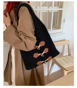 Détail du sac cabas en maille noire avec d'élégants fermoirs à bascule en cuir marron