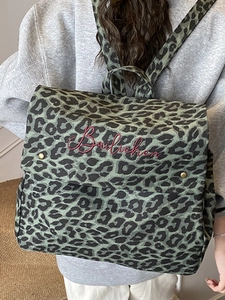 Fashionable leopard print backpack with red embroidery on a model for casual daily travel