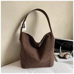 Detailed side view showing curved seams and matte texture of a vintage brown tote bag
