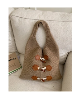 Détail du cabas en tricot avec attaches en cuir marron et fermetures à cordon blanc
