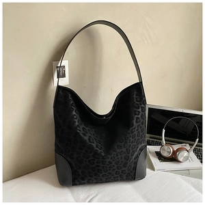 Detail of the large black leopard print hobo bag with reinforced leather corners and wide strap