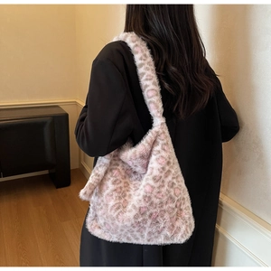 Detail of soft leopard print faux fur tote bag worn by a model in cozy interior