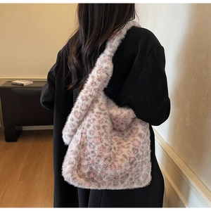 Detail of soft leopard print plush tote bag worn on shoulder over black outfit
