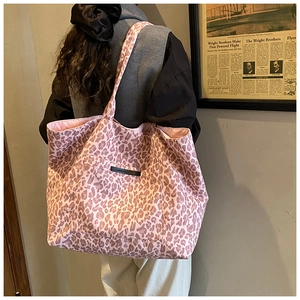 Detail of large leopard print tote bag showing pink fabric texture and outer pocket