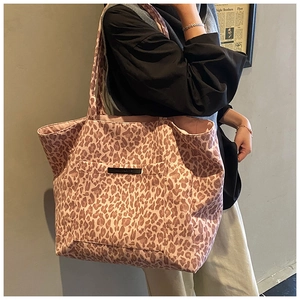 Detail showing the large outer pocket and pink leopard print pattern of the tote bag