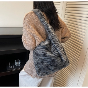 Detailed view of grey plush tote bag with striped texture on wide shoulder strap