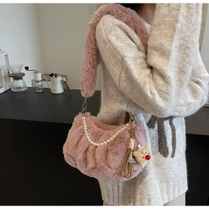 Détail du sac à bandoulière rose en peluche avec chaîne de perles et pendentif