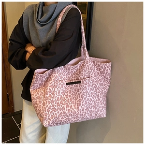 Detail of pink leopard print tote bag with side pocket and high-capacity canvas texture