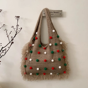 Détail du sac à bandoulière tricoté marron avec pompons colorés et longues franges