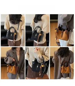 Detail of vintage bucket bag in black and caramel leather with decorative tassels