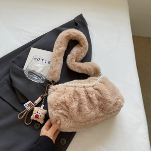 Détail du sac bandoulière beige en peluche avec chaîne de perles et texture plissée