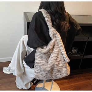 Detail of soft faux fur tote bag with brown and grey animal stripe pattern on shoulder