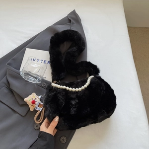 Détail du sac à bandoulière en peluche noire avec chaîne en perles et charm mignon