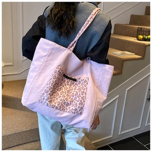 Detailed shot of large pink tote bag with leopard print pocket and shoulder strap
