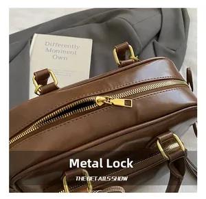 Détail du sac en cuir marron avec fermeture éclair en métal doré et boucles de qualité