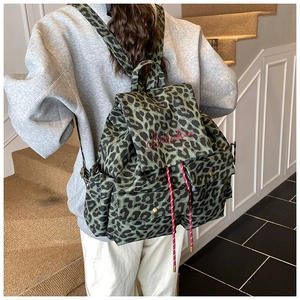 Detail view of large leopard print canvas backpack with red embroidery and drawstring