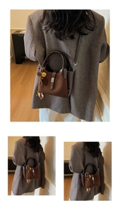Detail of dark brown bucket bag with tassel and pompom, shown on a wool blazer
