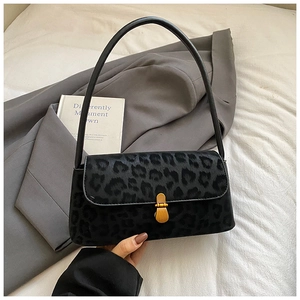 Detail of vintage leopard print shoulder bag with gold twist lock on grey suit fabric