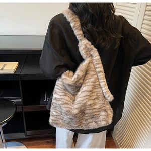 Close-up of fluffy faux fur tote bag with brown tiger stripes and wide shoulder strap