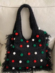 Grand sac cabas en maille noire avec pompons colorés et détails de franges latérales