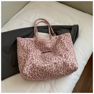 Detail of a large pink leopard print canvas tote bag with front pocket and spacious interior