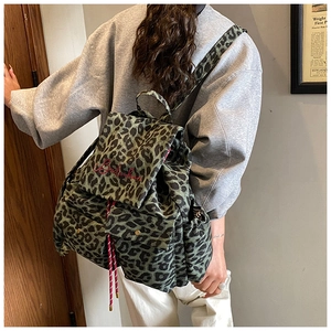 Detail of green leopard canvas backpack with red embroidery and drawstring closure