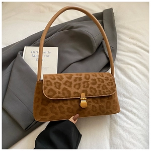 Close-up of leopard print baguette bag with golden metal lock and leather handle