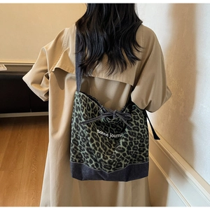 Détail du sac léopard avec nœud papillon et inscription Bonne journée à l'épaule
