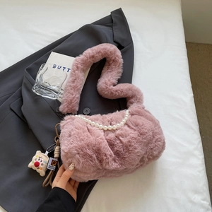 Détail du sac en fausse fourrure rose avec chaîne en perles et breloque petit biscuit