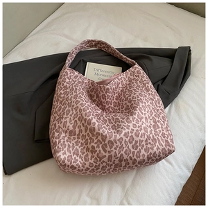 Detail of leopard print tote bag on white bedding with blazer for styling reference