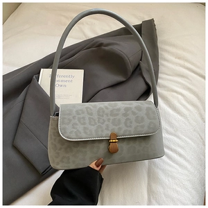 Detail view of grey leopard print shoulder bag with wood-textured metallic buckle closure