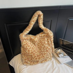 Close-up of a large leopard print plush tote bag in a cozy home lifestyle setting