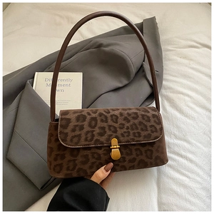 Detail of vintage leopard print suede shoulder bag with golden metallic clasp buckle