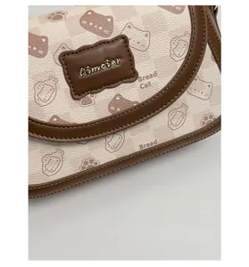 Detail of vintage square bag showing bread cat pattern and brown leather trim
