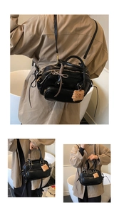 Détail du sac à main noir multi-poches avec breloque biscuit et finition en simili cuir
