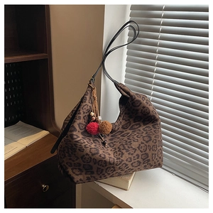 Detail of leopard print hobo bag with plush texture and decorative boho tassel