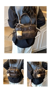 Détail du sac Boston vintage marron foncé avec un charmant pendentif biscuit en peluche