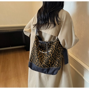 Détail du sac cabas à imprimé léopard avec patchwork en denim et texte imprimé