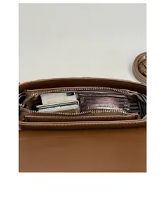 Detail view of brown leather bag interior with striped lining and organized compartments