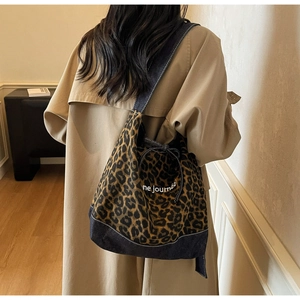 Détail du sac cabas en toile léopard avec empiècements en denim et cordon de serrage