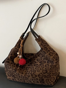 Retro leopard print tote bag with black leather straps and colorful plush ball charm