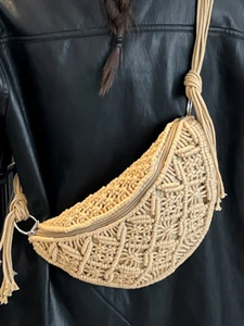 Handwoven beige macrame crescent crossbody bag with braided shoulder strap on model