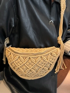 Handmade beige macrame sling bag with tassel charms and geometric woven pattern