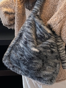 Large striped faux fur tote bag in grey and black shown on model for winter styling