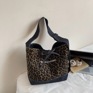 Détail du sac en toile imprimé léopard avec bordure en denim et slogan blanc élégant