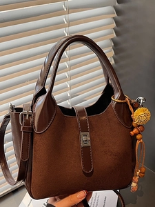 Fashionable dark brown leather bucket bag with metallic lock and floral tassel accessory