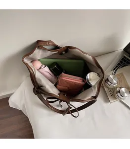 Interior view of large brown leather tote bag with gray lining and magnetic closure