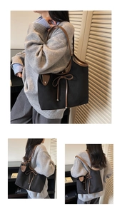 Close-up of black canvas tote bag with brown leather bow detail and metallic beads
